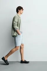 Bermuda de jean con corte regular fit, confeccionada en denim de algodón con elasticidad. Presenta diseño de cinco bolsillos, efecto lavado y cierre frontal con cremallera y botón.