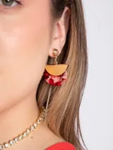 Caravanas colgantes con base de metal dorado y diseño semicircular que combina una pieza dorada lisa con un aplique inferior de resina en tonos rojo y blanco con efecto marmoleado.