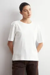 Remera de corte oversized, color verde oliva, con cuello redondo y mangas cortas.