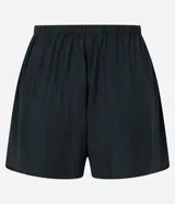 Short de playa color beige, confeccionado en viscosa y poliamida, con diseño holgado, bolsillos laterales, cintura elástica con cordón de ajuste tipo lazo y detalle de botones frontales.