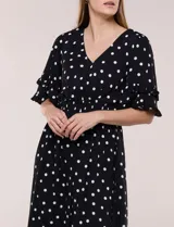 Vestido midi de calce holgado y caída fluida con escote en V cruzado, cintura elastizada fruncida y mangas cortas con volados superpuestos. Cuenta con un diseño estampado de flores grandes en tonos amarillo, blanco, azul marino y verde.