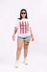 Remera oversize blanca de algodón suave con cuello redondo, con un estampado central que combina franjas verticales rojas y la frase 'bon appétit!' escrita en azul con tipografía cursiva.