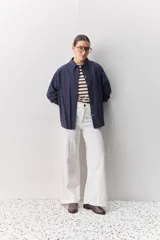 Camisa celeste de corte oversize, con mangas largas, cuello camisero y cierre frontal de botones.