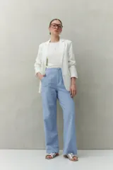 Pantalón negro de corte recto y tiro alto, confeccionado en denim con costuras a contratono en color blanco. Presenta bolsillos frontales tipo parche y cierre frontal con botón y cremallera.