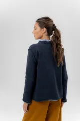 Saco básico de punto color marfil, confeccionado en lambswool, con corte entallado tipo chaquetita. Destaca por detalles de blonda tejida en los puños y a lo largo de la abertura frontal, con bordes en color contrastante.