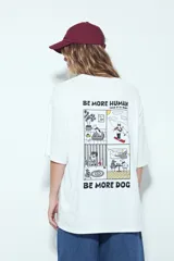 Remera blanca de manga corta, cuello redondo y calce relajado. Presenta un pequeño estampado frontal de un perro con un hueso y un estampado grande en la espalda con la frase "WILD HEART" y un diseño gráfico.