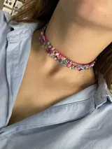 Gargantilla corta con base de tela rosada y apliques de piedras de colores y strass.