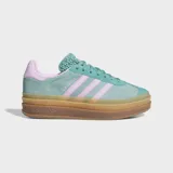 Championes Adidas Gazelle Bold de plataforma, confeccionados en gamuza color verde agua con detalles en rosa pastel. Presentan la icónica silueta de la marca con suela de caucho apilada en tonos caramelo y cierre de cordones.