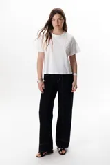 Pantalón negro de corte recto, pierna ancha y tiro alto, con detalles de pespuntes blancos a contratono.