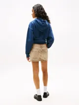 Buzo azul con capucha y cordón ajustable, de corte holgado y largo cropped. Presenta un bolsillo tipo canguro y puños y bajo de punto canalé. Estampado frontal con el logo de Tommy Jeans.