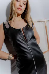 Vestido largo negro de cuero ovino con cierre frontal de cremallera metálica, sin mangas y con tajo lateral.