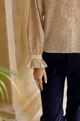 Camisa de algodón con estampado floral, cuello clásico, cierre frontal con botones, mangas largas con puños con volados y corte recto.