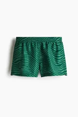 Short de baño con estampado de líneas onduladas en tonos verdes. Cuenta con cintura elástica con cordón de ajuste, bolsillos laterales y suspensor interior de malla.