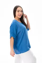 Blusa azul de corte holgado con mangas cortas arremangadas y escote redondo.