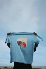 Remera blanca de algodón con cuello redondo y mangas cortas. Estampado pequeño en el pecho de un hombre haciendo una pose.