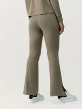 Calza pantalón color verde oliva, tipo flare, de tejido Peach_T con tacto de piel de melocotón. Tiene bajo acampanado ligero con aberturas, costuras decorativas y bolsillos laterales.