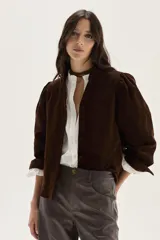 Camisa de pana color chocolate, con corte recto, cuello mao y mangas largas abullonadas con puños ajustados.