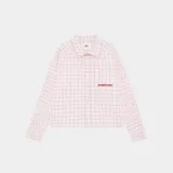 Camisa de manga larga con cuello y botones frontales, corte boxy, en color blanco con estampado de cuadrícula fina en tono rosado. Presenta un pequeño logo bordado en rojo en el pecho.