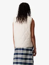 Chaleco acolchado color beige claro, con cuello en V, cierre frontal de botones a presión y bolsillos de parche en el pecho y la parte inferior delantera.