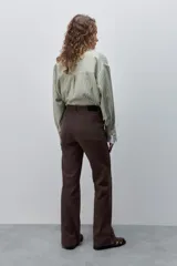 Pantalón de jean azul marino, de tiro alto y calce ajustado con pierna recta levemente amplia, bolsillos traseros y recortes verticales en el delantero.