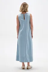 Vestido largo de jean celeste, sin mangas, con escote en V profundo, corte holgado y costuras visibles a contratono.