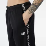 Pantalón de jogging negro de frisa, con puños ajustados y logo de New Balance estampado en blanco a lo largo de la pierna.