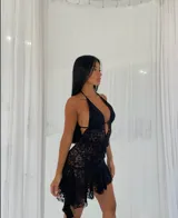 Vestido corto negro de encaje con escote halter y espalda descubierta.