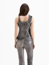 Top entallado estilo corsé de cuero ovino gris, con acabado encerado parafine, diseño asimétrico con volados en un bretel y cierre metálico central.