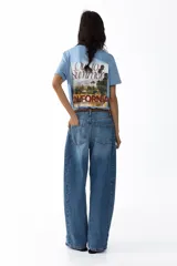 Jeans de corte barrel en denim de algodón, de tiro medio y diseño holgado con piernas curvas. Presenta diseño de cinco bolsillos, trabillas para cinto y cierre frontal con botón y cremallera.