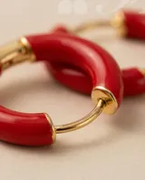 Aros tipo argolla pequeña de acero dorado con esmaltado en color rojo.