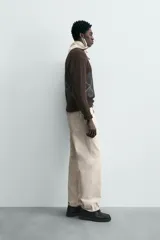 Jersey de punto marrón oscuro con diseño jacquard de rombos en gris y blanco, cuello redondo y manga larga.