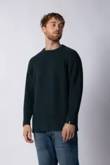 Sweater de tejido grueso con cuello redondo, mangas largas con puños acanalados y corte relajado.