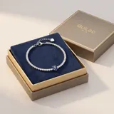 Pulsera de plata 925 tipo tenis, con una hilera de circonias blancas y un dije central de circonia azul en forma ovalada.