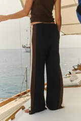 Pantalón tejido de punto con diseño de bloques de color, con franjas laterales en contraste de tonos marrón y beige. Presenta corte recto y cintura elástica.