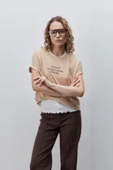 Remera blanca de silueta amplia y calce relajado, confeccionada en tela suave y liviana, con cuello redondo, mangas cortas con vuelta y hombros caídos. Cuenta con un delicado bordado frontal en color azul con la inscripción "LE SOLEIL TOUTE L'ANNÉE sur la Côte d'Azur".