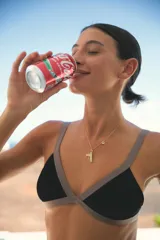 Conjunto de bikini negro con corpiño triangulito con breteles regulables y bombacha vedetina regulable. Ambos con vivos en lycra brillante color visón.