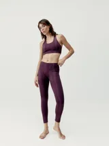 Top deportivo de sujeción media, color azul con diseño de líneas verticales en degradé. Tiene tirantes finos dobles cruzados en la espalda y logo en el frente.