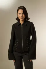 Sobrecamisa de jean color negro con cierre frontal, cuello clásico y detalle de cordones laterales ajustables con ojalillos metálicos.