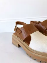 Sandalias de cuero color camel y crudo, con plataforma track y hebilla ajustable.