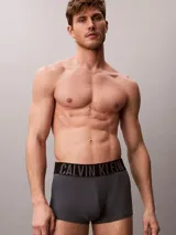Pack de tres bóxers ajustados Calvin Klein de talle medio, confeccionados en mezcla de algodón y elastano. Incluye una unidad gris melange, una blanca y una azul, todas con cinturilla elástica negra distintiva de la marca.