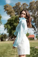 Camisa celeste de broderie con hombro y manga globo con puño.