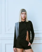 Top manga larga negro confeccionado en rayón con hilera de botones broche asimétricos.