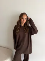 Conjunto de dos piezas color tostado, compuesto por un buzo de cuello redondo con mangas largas y hombros caídos, y un pantalón de corte recto con cintura elástica y cordón ajustable.