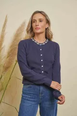 Saco de punto color azul marino, con cuello redondo y detalles de strass en el escote. Cierre frontal con botones de strass.