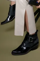 Botin de cuero color bordeaux con diseño de textura combinada, punta cuadrada y hebilla metálica lateral.
