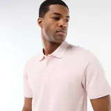 Remera tipo polo de manga corta en color rosa claro, con cuello clásico y cierre frontal de botones.