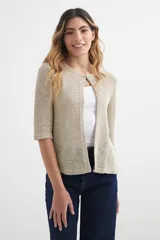 Cardigan color beige de tejido de punto con mangas 3/4 y cierre con un único botón en el cuello.