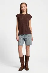 Bermuda de jean de tiro alto con diseño cropped y bolsillos con apliques decorativos.