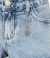 Short de jeans de tiro bajo, color celeste claro desgastado, con trabilla, cierre tradicional y bolsillos. Incluye una cadena decorativa con dijes de estrellas.