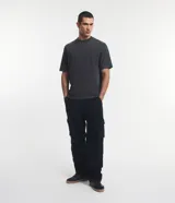 Remera de corte boxy y diseño liso, confeccionada en algodón con efecto desteñido, cuello redondo alto y mangas cortas.